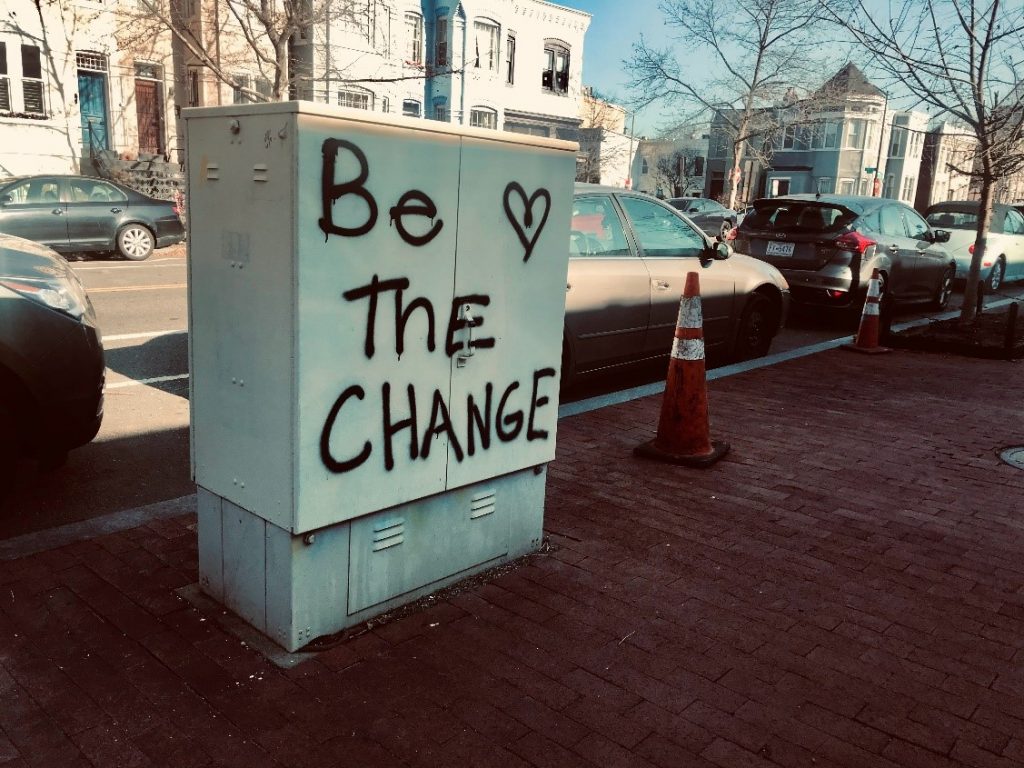 Kadulla olevaan sähkökaappiin on spray-maalilla kirjoitettu lause be the change.