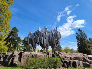 A picture of the Sibelius monument with a blue sky and green trees in the background.